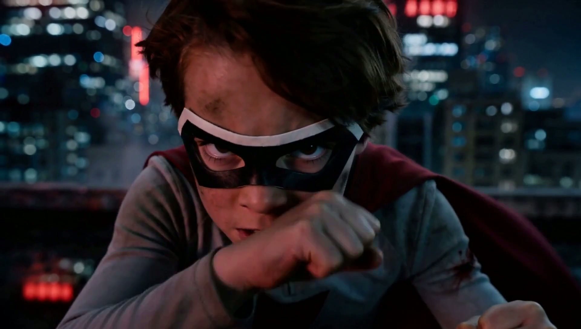 Frame from The Last Battle: close-up of the masked boy, fists up, in the neon night