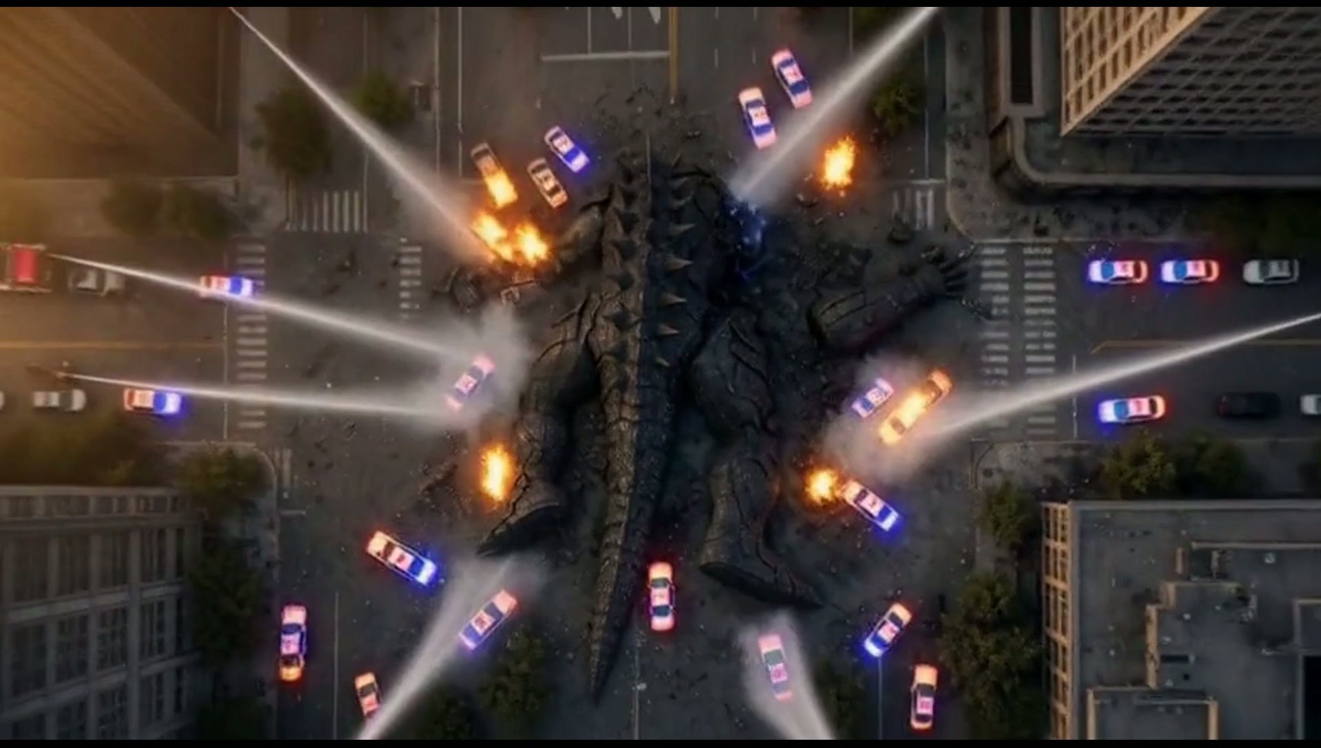 Frame from The Last Battle: aerial view of the creature down, police lights fanned out around it